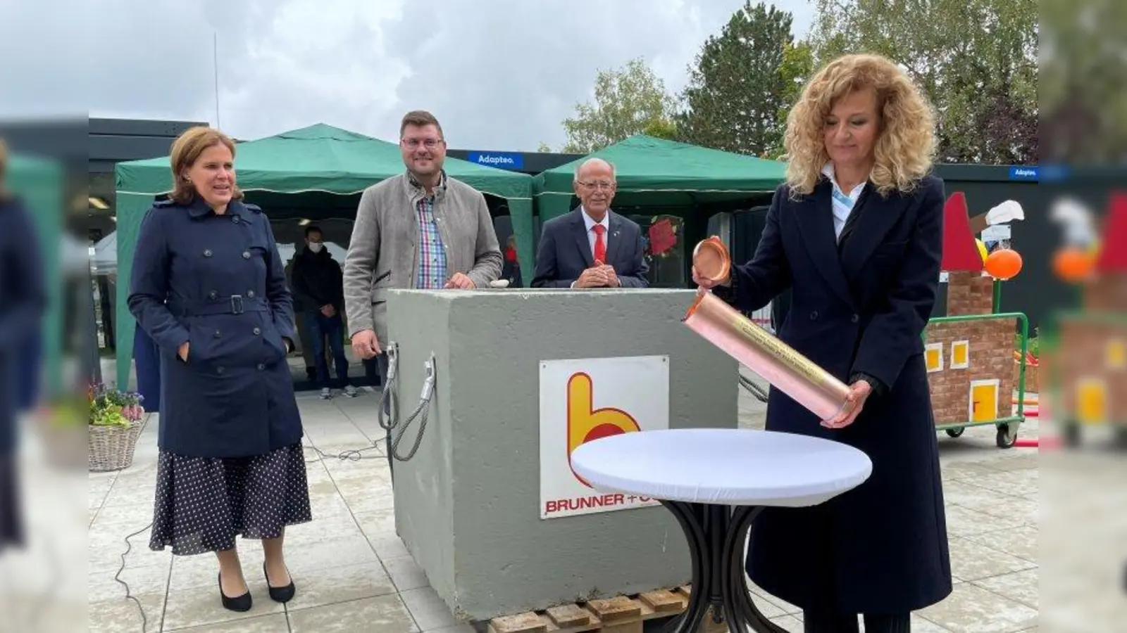 Nariman Zimpel (r.) schließt die Zeikapsel. Am Grundstein schauen Verena Dietl, Sebastian Kriesel und Josef Mederer zu (v.l.). (Foto: pst)