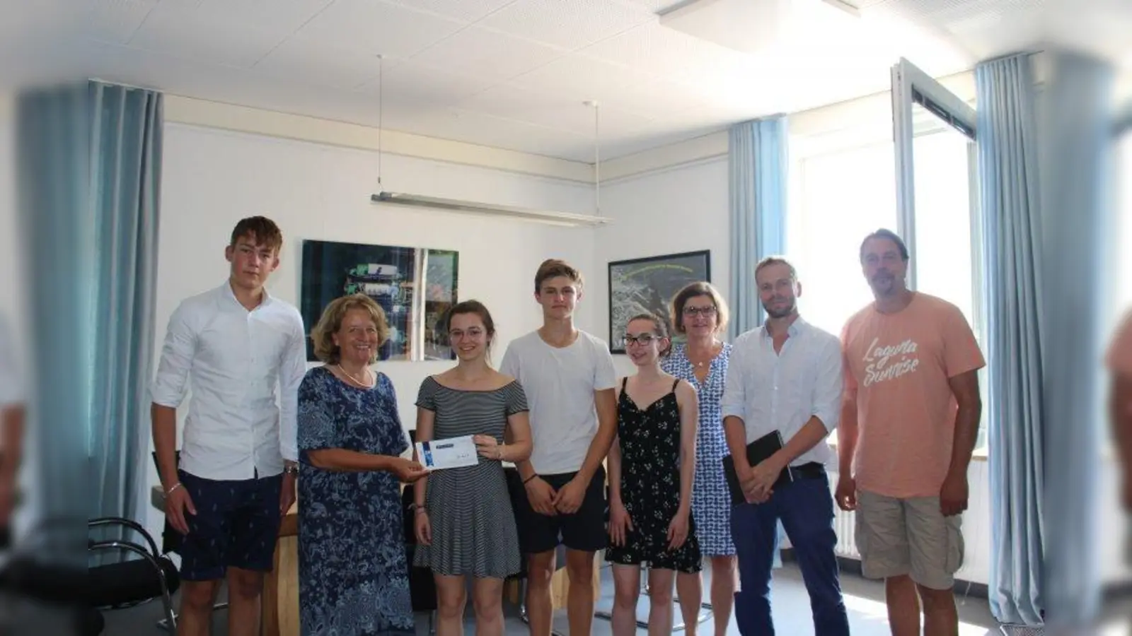 Die erste Aktie der Schülerfirma kaufte Bürgermeisterin Eva John  für die Stadt. Mit auf dem Bild Projektsprecher Maximilian Picker mit drei Mitschülern des P-Seminars und Lehrerin Christine Schulz, sowie Benjamin Tillig (Museum Starnberger See) und Jesco Ringwald (Seebad Starnberg). (Foto: Stadt Starnberg)