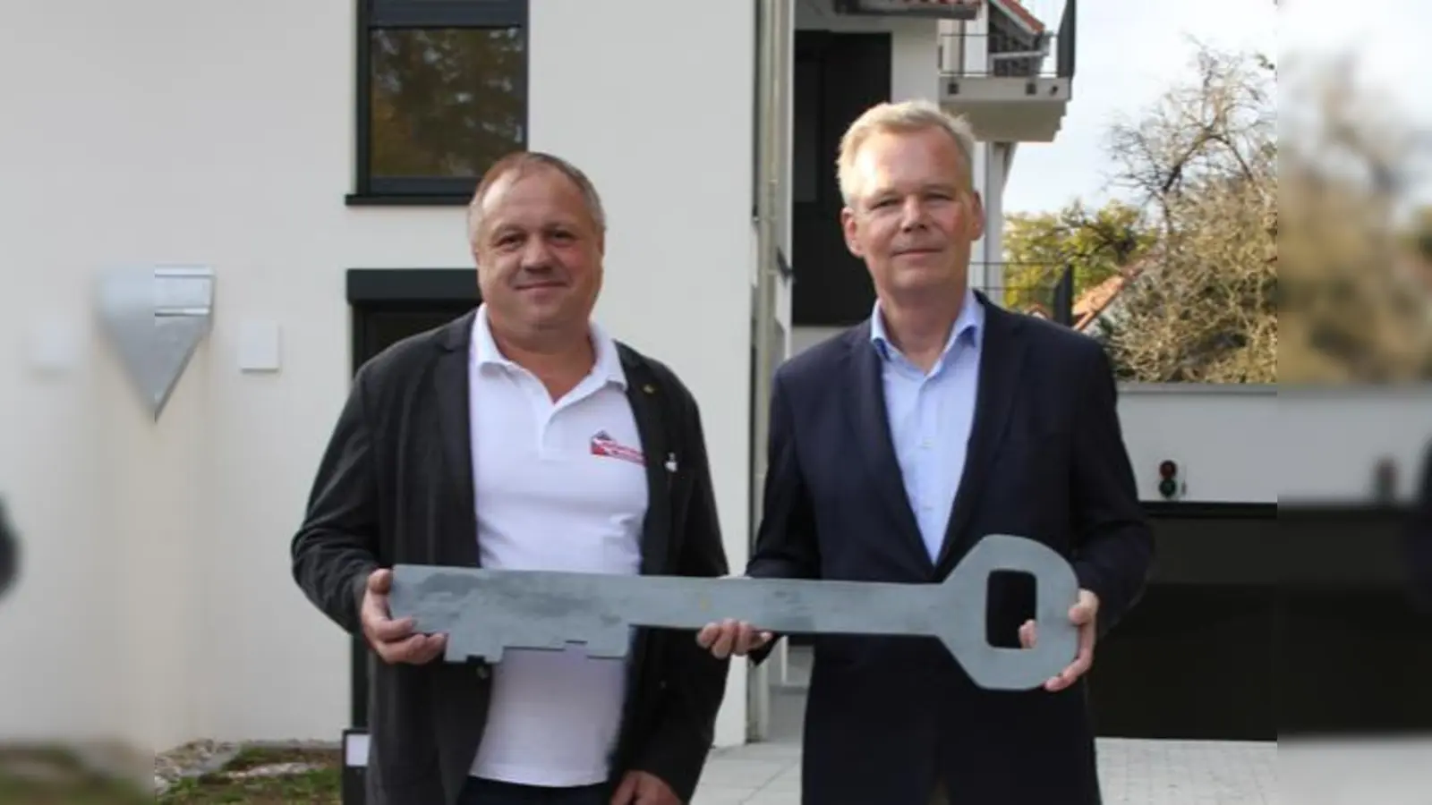 Grünwalds Bürgermeister Jan Neusiedl (r.) bekam vom Bauunternehmer Andreas Kolbinger den offiziellen Schlüssel zum kommunalen Wohnbauprojekt überreicht.  (Foto: Heike Woschee)