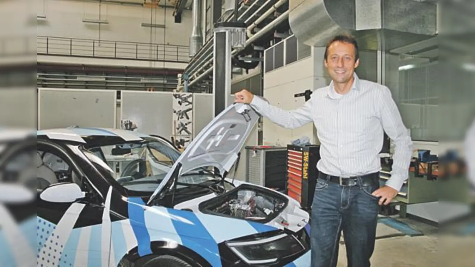 Markus Lienkamp vor einem Elektroauto der TU München, die ein Elektrofahrzeugkonzept entwickelt.  (Foto: scy)