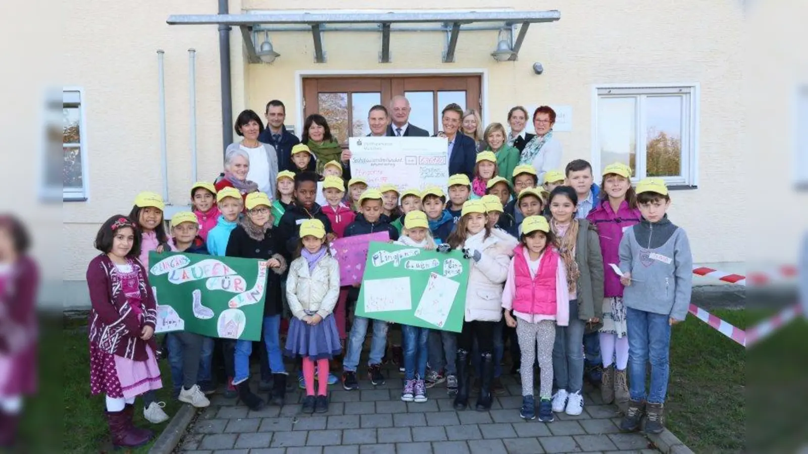 Bei der offiziellen Scheckübergabe vor dem Eingang der Schule überreichte Grundschulrektorin Ulrike Bauer (hinten Fünfte von rechts) den Scheck an den Rektor der Betty-Greif-Schule Fritz Preisinger (Vierter von links). Mit auf dem Bild Simbachs Bürgermeister Klaus Schmid (Sechster von rechts) und MdL Reserl Sem (rechts). (Foto: Walter Geiring)