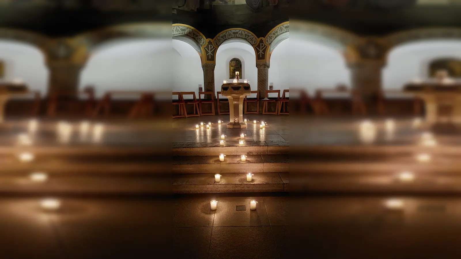 Beim Taizé-Gebet wird der Taufstein der Erlöserkirche mit Kerzen beleuchtet.  (Foto: © Tabea Bleher )