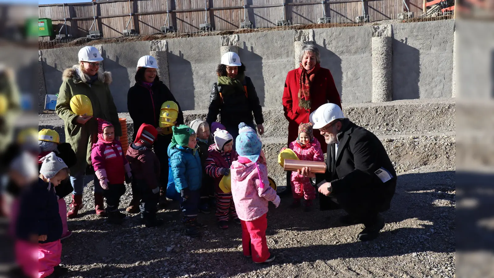 Bürgermeister Dr. Stefan Straßmair zeigt den kleinen „Wichteln“ die Zeitkapsel, die bei der Grundsteinlegung versenkt wurde.  (Foto: Gemeinde Hohenbrunn)
