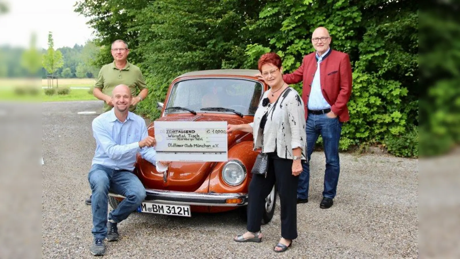 10.000 Euro sammelten die Oldtimer-Fans für einen guten Zweck: V.l. Vom Oldtimer Club kamen Marcus Gebhard und Christoph Maas (Eigentümer des VW Käfer Cabrio 303 LS). Karin Wolf vom Würmtaltisch und Kraillings Bürgermeister Rudolph Haux bei der Spendenübergabe. (Foto: us)