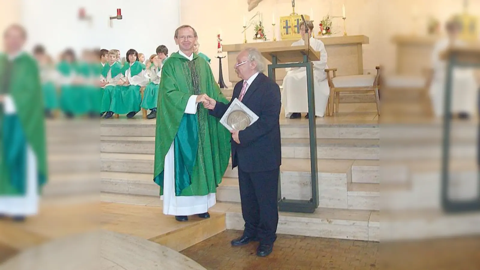 Pfarrer Dr. Lukasz überreicht dem scheidenden Chorleiter Peter Graßhold einen gravierten Zinnteller.	 (Foto: Privat)