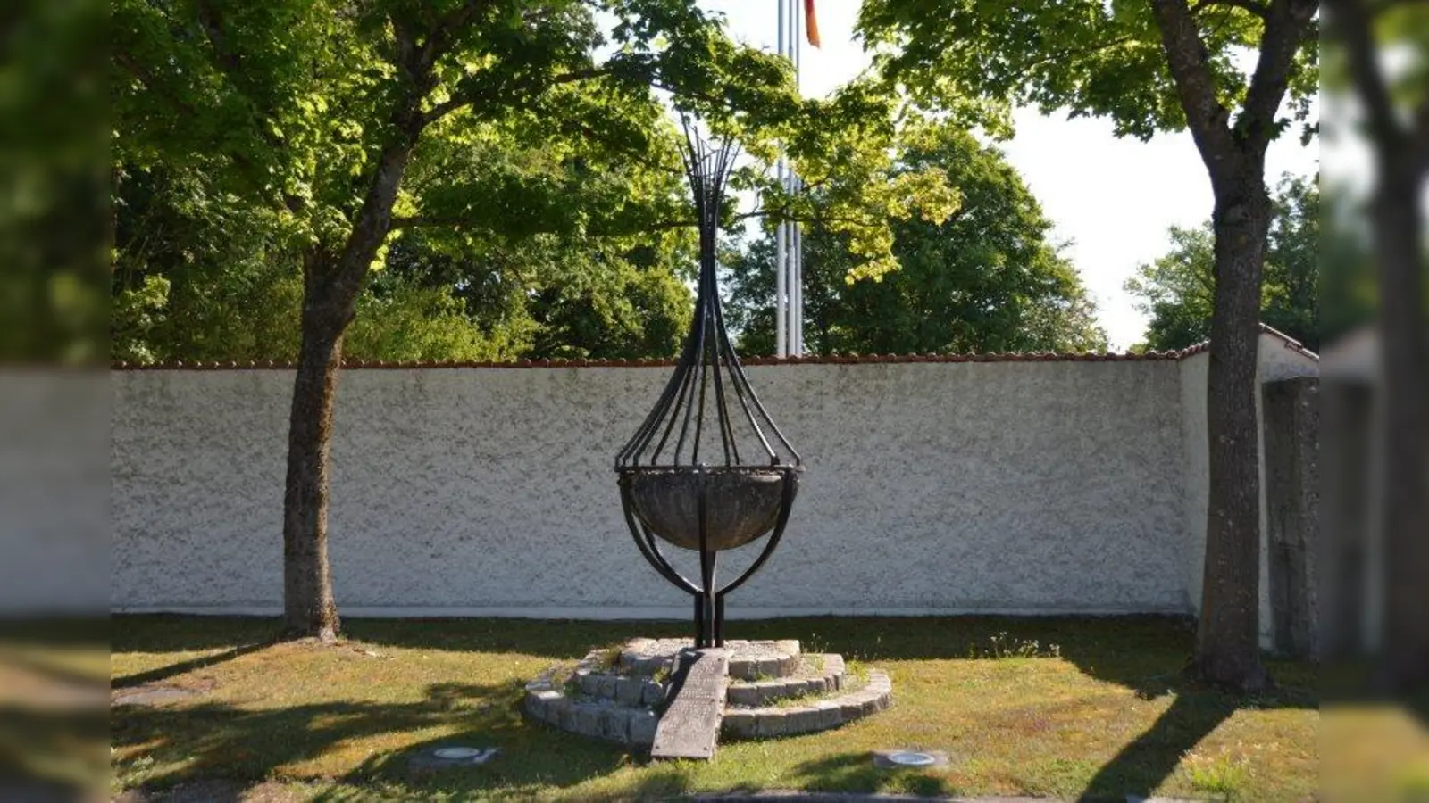 Die zwölf Flammenstrahlen symbolisieren die  Söhne Jakobs und die daraus erwachsenen zwölf Stämme Israels. Sie erinnern auch an die zwölf Ermordeten vom September 1972. Schließlich verweisen sie auf die Olympische Flamme. Auf der Bodenplatte sind die Namen der Opfer eingraviert. (Foto: LRA FFB)