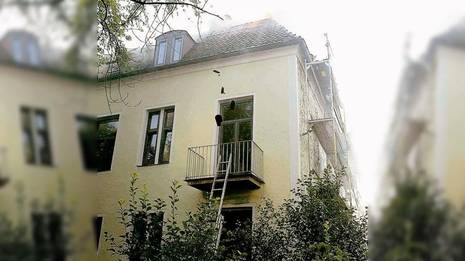 Das Feuer im Dachstuhl brannte so sehr, dass sich starker Rauch entwickelte und Ziegel vom Dach fielen. 	 (Foto: Feuerwehr München)