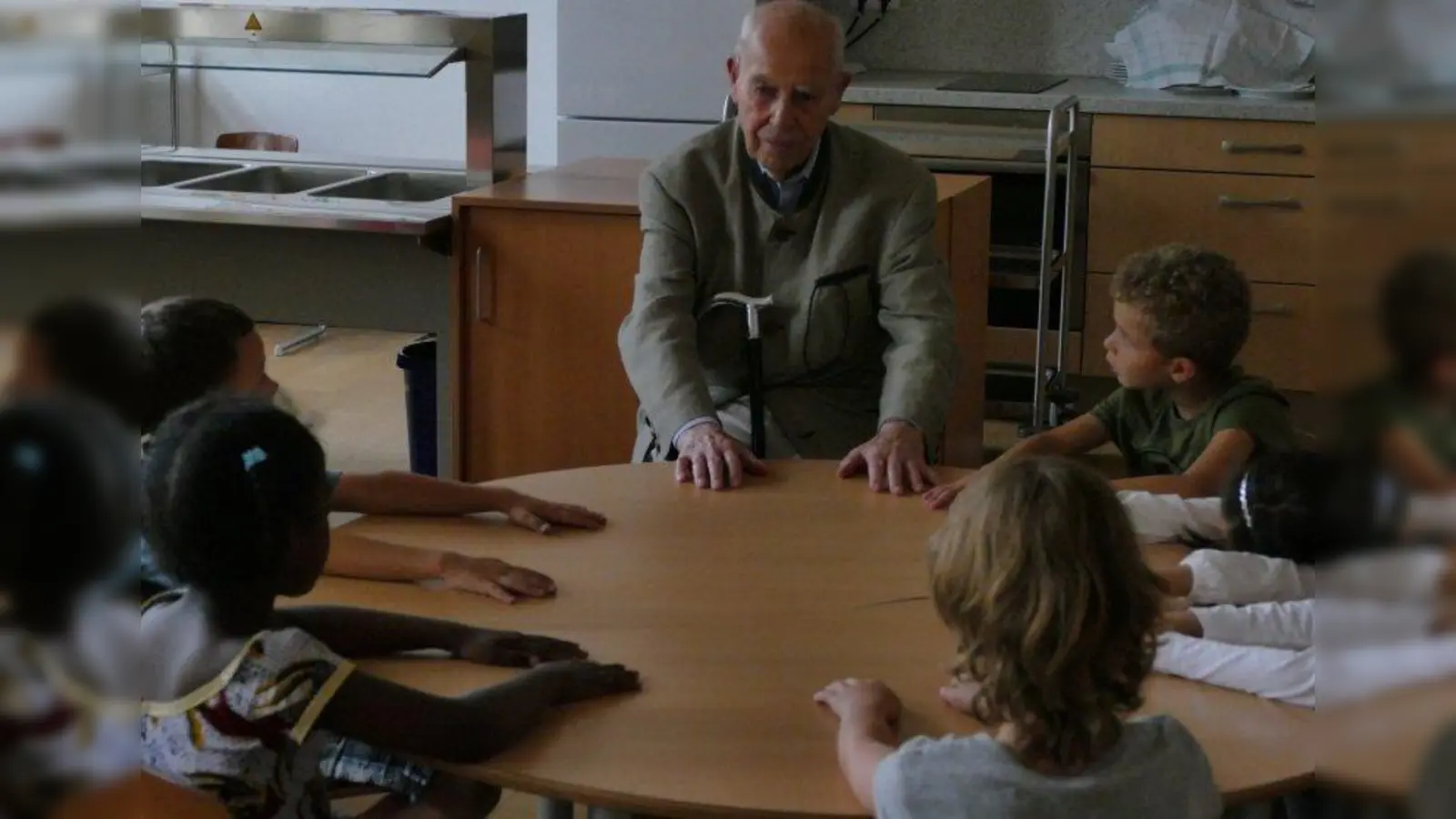„Wenn es in der Klasse laut war sagte unser Lehrer: Jetzt setzen wir uns alle ganz ruhig hin und legen die Hände auf den Tisch”: Das zeigte der 92-jährige Rudolf Wolf den Erstklässlern. (Foto: ds)