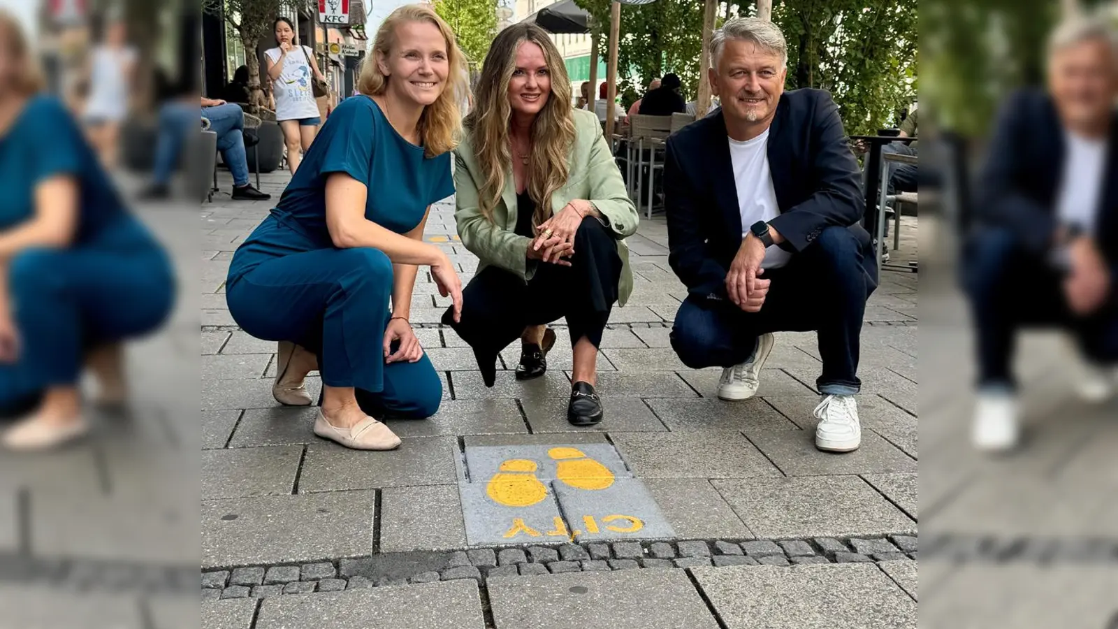 Leuchtend gelb sind die Fußspuren, die vom Hauptbahnhof in die Innenstadt führen. Das neue Leitsystem stellten (v.l.) Hanna Sammüller, Mona Fuchs und Stefan Reisinger vor.  (Foto: KVR)