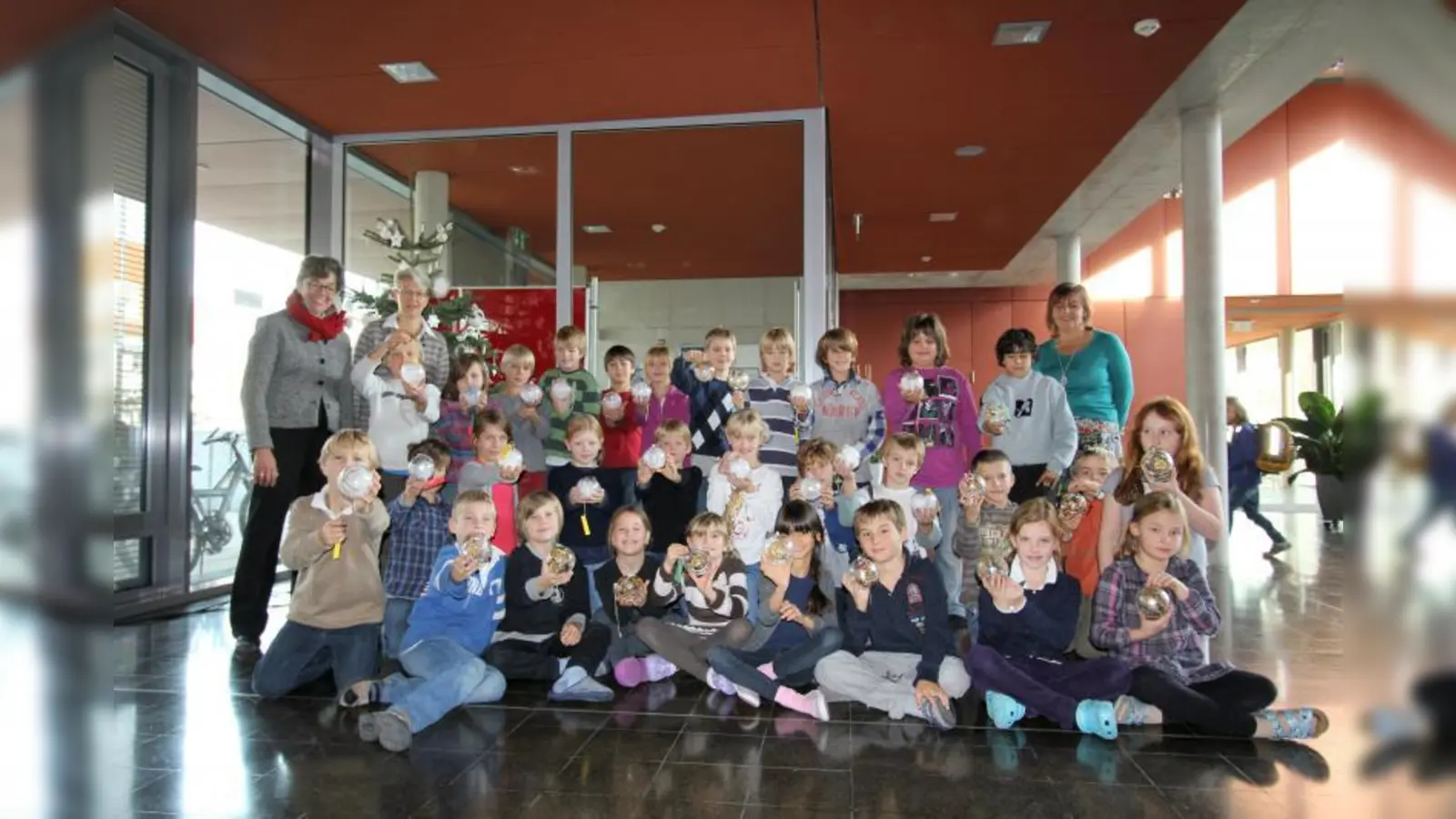 Gemeinschaftsaktion vieler für einen guten Zweck: Petra Schaber und Karin Prager (v.l.) mit den kleinen Künstlern aus der dritten und vierten Klasse. Rechts Grundschulrektorin Angelika Nerz-Lidl. (Foto: US)