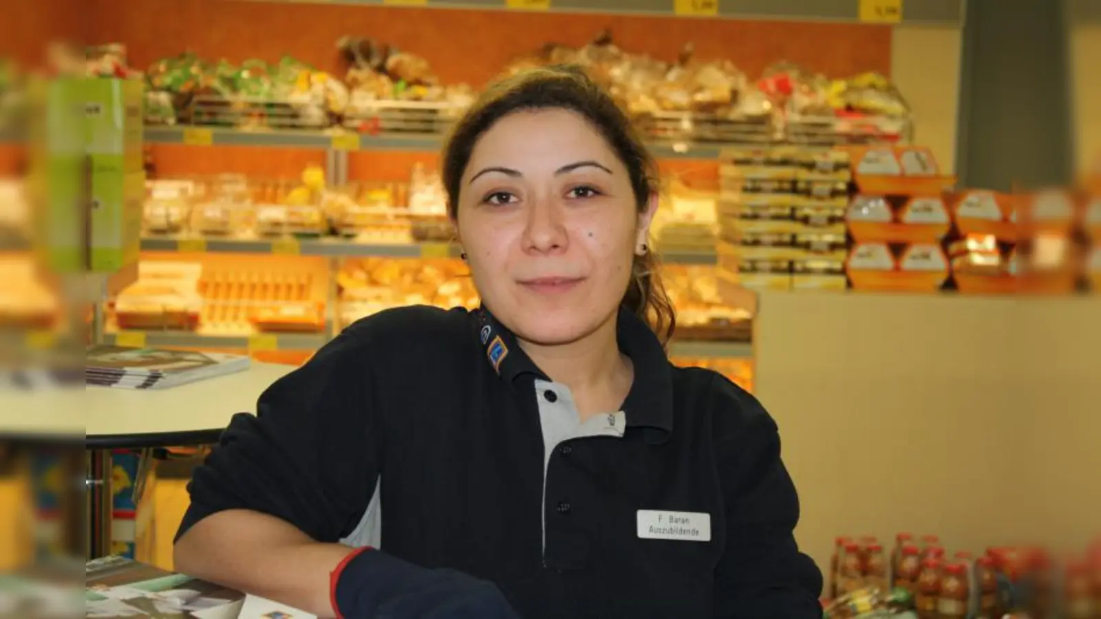 Funda Baran, 28 Jahre, Filiale Frankfurter Ring: „Unser Teamwork funktioniert mittlerweile wunderbar. Wir mussten uns natürlich erstmal von Beginn an zusammenfinden, denn es ist für uns sehr wichtig, dass wir im Team gut arbeiten. Ich bin schon seit sechs Jahren Mitarbeiterin bei ALDI SÜD und habe mich bewusst für eine Ausbildung hier im Unternehmen entschieden. Mein Ziel ist es nämlich, irgendwann in absehbarer Zukunft einmal selbst eine Filiale zu leiten. Von daher hilft mir die Azubifiliale hier extrem weiter. Für mich als Quereinsteigerin ist es unglaublich toll, dass mir ALDI SÜD die Chance zur Ausbildung gegeben hat. Ich habe so noch einmal sehr viel gelernt. Auch hier in der Azubifiliale bin ich auf alle Fälle an der Aufgabe gewachsen und habe noch einmal einen guten und direkten Blick in die Abläufe bekommen.“ (Foto: sb)