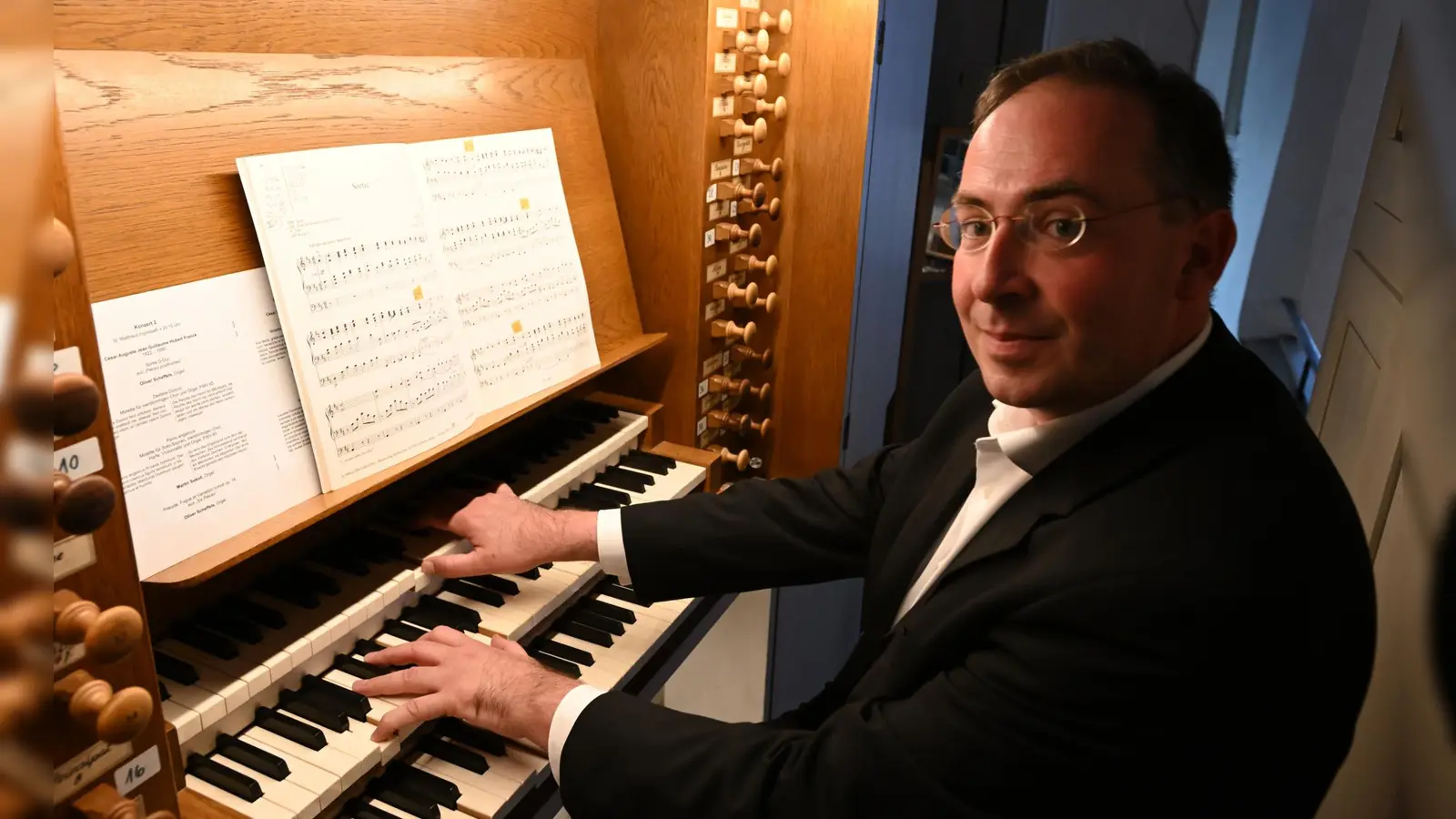 Oliver Scheffels studierte Orgel und Evangelische Kirchenmusik an der Münchener Musikhochschule. Im Sommer 2000 erhielt er sein Orgeldiplom, 2003 schloss er sein Kirchenmusikstudium mit dem A-Examen ab. Er hat internationale Orgelmeisterkurse besucht, vorwiegend zur Interpretation von französischer Orgelsymphonik und zur Improvisation. Seit seinem Studium geht er einer regen Konzerttätigkeit nach. Von 2005 bis 2012 bekleidete er das Kantorenamt in Greiz, vom Dezember 2012 bis 2021 arbeitete er als Kantor und Organist an der Petruskirche in Neu-Ulm und als Dekanatskantor im Dekanatsbezirk Neu-Ulm und verantwortete dort ein umfangreiches musikalisches Jahresprogramm. Von 2013 bis 2015 hat er in 16 Konzerten das gesamte Orgelwerk von J. S. Bach gespielt. 2015 wurde er zum amtlichen Orgelsachverständigen der Evang.-Luth. Landeskirche in Bayern ernannt. 2019 erfolgte die Ernennung zum Kirchenmusikdirektor. Seit Oktober 2021 wirkt Oliver Scheffels als Dekanatskantor an St. Matthäus in Ingolstadt. (Foto: Bernhard Schaffer)