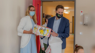 Zur Eröffnung des neuen Gronsdorfer Kindergarten brachten Kerstin Onwuama (Leitung Bildung und Soziales der Gemeinde Haar) und Bürgermeister Dr. Andreas Bukowski ein Geschenk für die Kinder mit. (Foto: Gmeinde Haar)