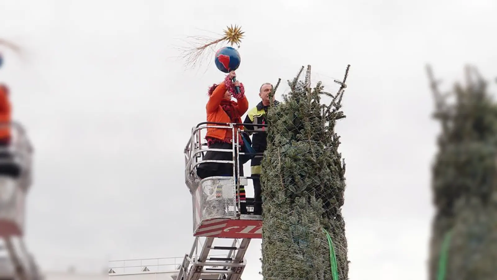 Anbringen der Christbaumspitze,  gefertigt von der Frauenkunstwerkstatt von LebensArt e.V.  (Foto: VA)