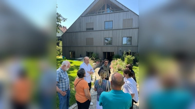 Der Derzbachhof mit Besuchergruppe, Architekt Peter Haimerl und Verwalter der Gemeinschaftsflächen Simon Weber von Qonzep zusammen mit Grünen Politikern.  (Foto: Vorbrugg/Denhauser)