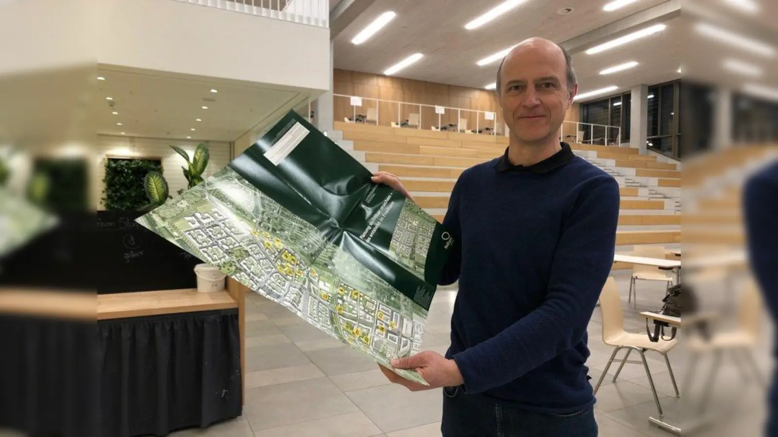 Stadtteilmanager in Freiham, Reinhold Petrich, präsentiert den neuen Faltplan. (Foto: pst)