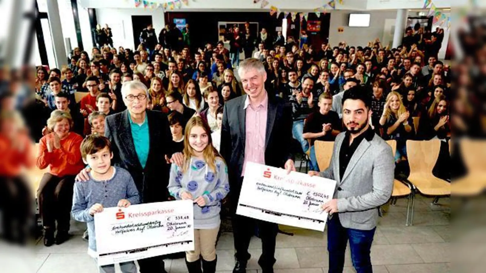 Schüler der Klasse 6c, Claudia Bernardoni (Helferkreis Asyl Ottobrunn), Schülerin der Klasse 6c, Achim Lebert (Direktor des Gymnasiums Ottobrunn) und Rony Goliana (Flüchtling, Helferkreis Ottobrunn) (vl l.) bei der Scheckübergabe.	 (Foto: Schunk)