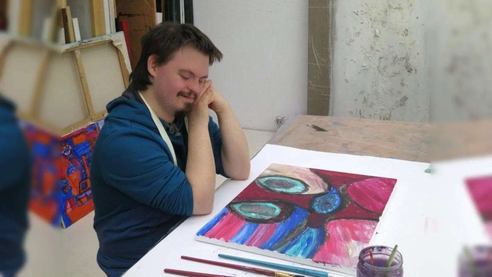 Gerhardt Folkmer gehört zur inklusiven Künstlergruppe „Sesam öffne Dich”. Sein Leinwandbild, über dessen Fertigstellung er sich hier freut, wird in der Köskival-Ausstellung gezeigt. (Foto: Anja Verbeek von Loewis)