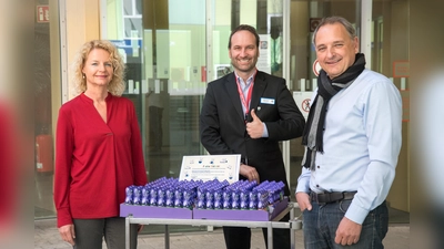 Tamara Berbuir und Michael Nerreter (rechts) vom Kinderschutzbund Ebersberg übergeben Klinik-Geschäftsführer Stefan Huber 300 Schokoladen-Osterhasen als Dank an die Mitarbeiter. (Foto: KK)
