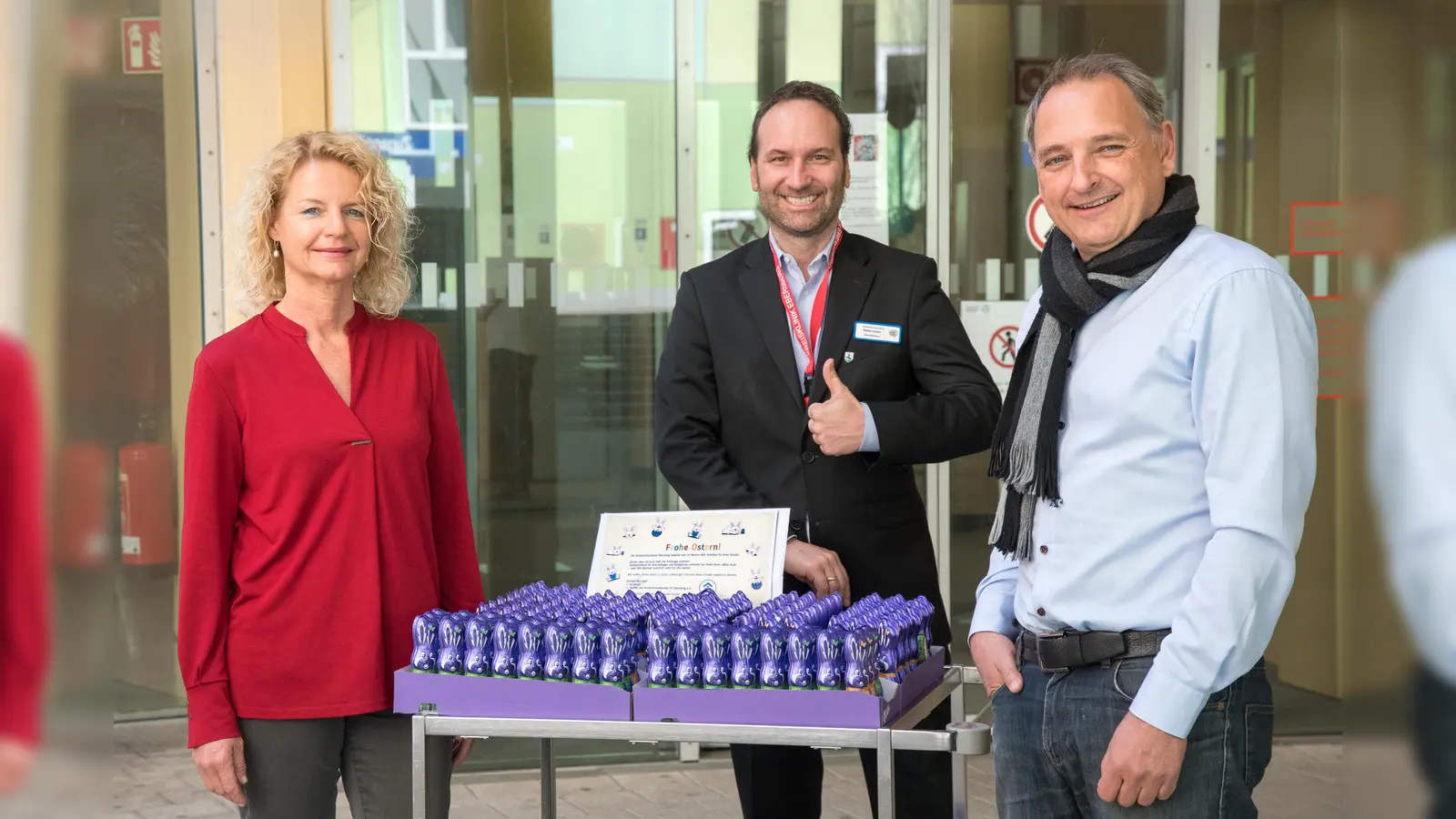Tamara Berbuir und Michael Nerreter (rechts) vom Kinderschutzbund Ebersberg übergeben Klinik-Geschäftsführer Stefan Huber 300 Schokoladen-Osterhasen als Dank an die Mitarbeiter. (Foto: KK)