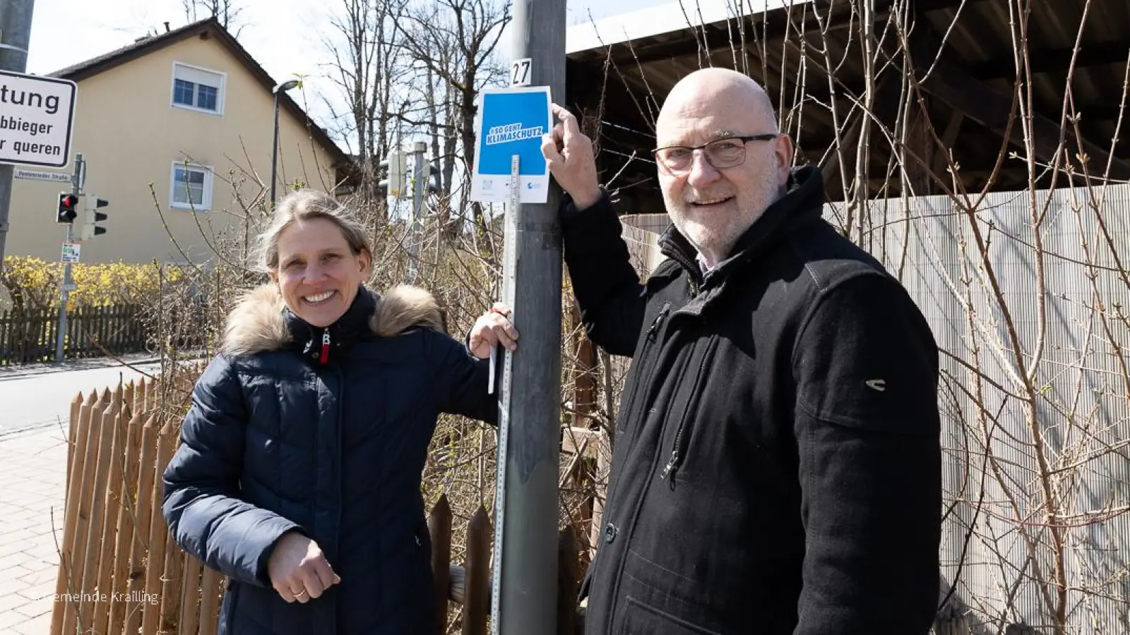 Klimaschutzbeauftragte Christine Papst und Bürgermeister Rudolph Haux kennzeichnen die auf LED-Leuchtmittel umgestellten Laternen. <br><br>  (Foto: © Gemeinde Krailling / Solveig Butzert )