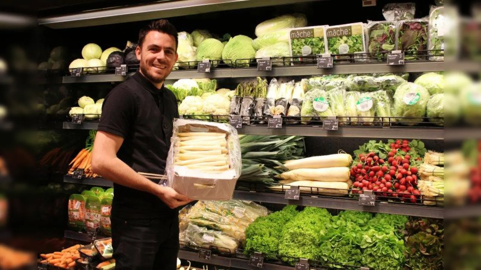 Burim Paqarizi, Mitarbeiter in der Gourmetabteilung der Galeria Kaufhof am Rotkreuzplatz, präsentiert den frischen Spargel aus Bayern. (Foto: sb)
