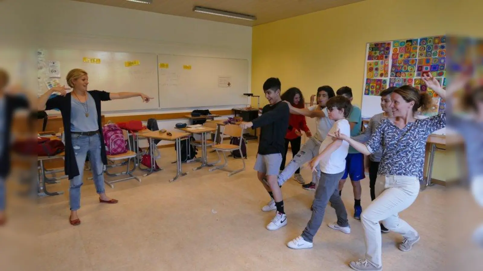 Impro-Spiel ohne Worte: Sophie Hechler projiziert ein Foto an die Wand und sagt, was darauf zu sehen sein soll. Die Schüler und Karin Ertl stellen das Gesagte blitzschnell dar. (Foto: ds)