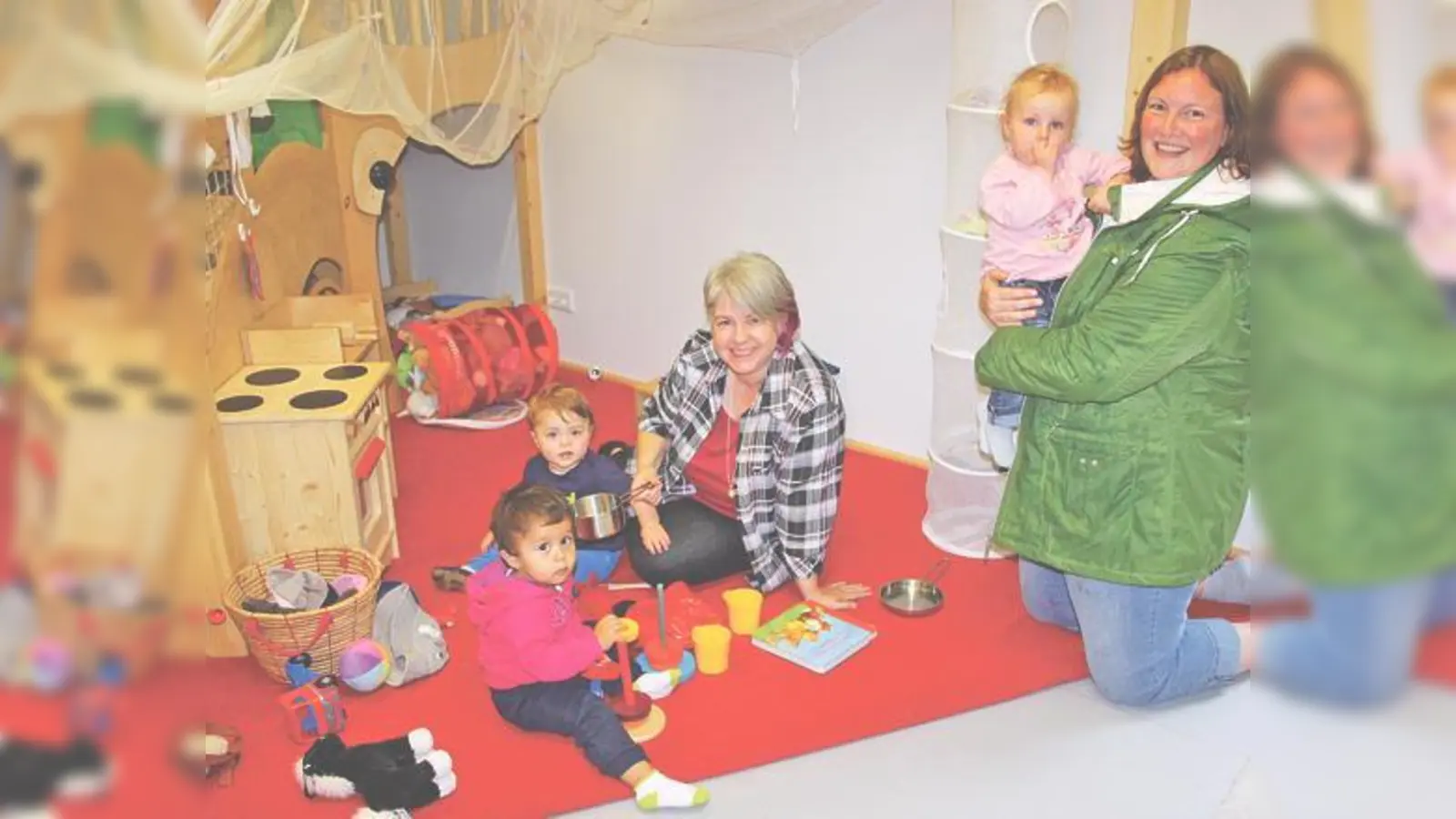 Einrichtungsleiterin Karin Wunderlich (Mitte) mit den Kindern und einer Mutter in einem der Gruppenräume der Krippe.	 (Foto: js)
