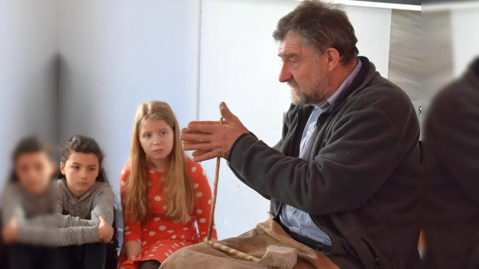 Der Archäologe und Steinzeitexperte Lothar Breinl demonstrierte Schülerinnen des MTG eine Methode, wie in der Steinzeit Feuer gemacht wurde. (Foto: MTG)