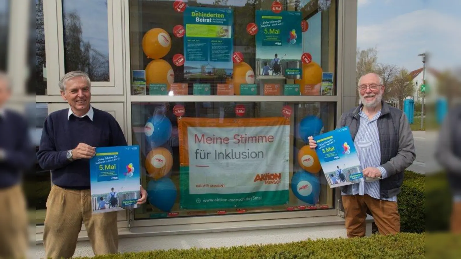 Alfred Ploetz, Mitglied des Behindertenbeirates und Hans Wannenmacher, Vorsitzender des Behindertenbeirates, vor dem Fenster der Inklusion. (Foto: Gemeinde Herrsching)