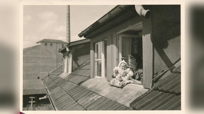Der Kleine geht heute schon auf die 70 zu: Hier schaut er um 1960 zusammen mit Mama aus dem Arbeiterwohnhaus „Kalkofen“ heraus. Im Hintergrund die Papierfabrik; 1982 wurde sie gesprengt.  (Foto: Schlossmuseum)