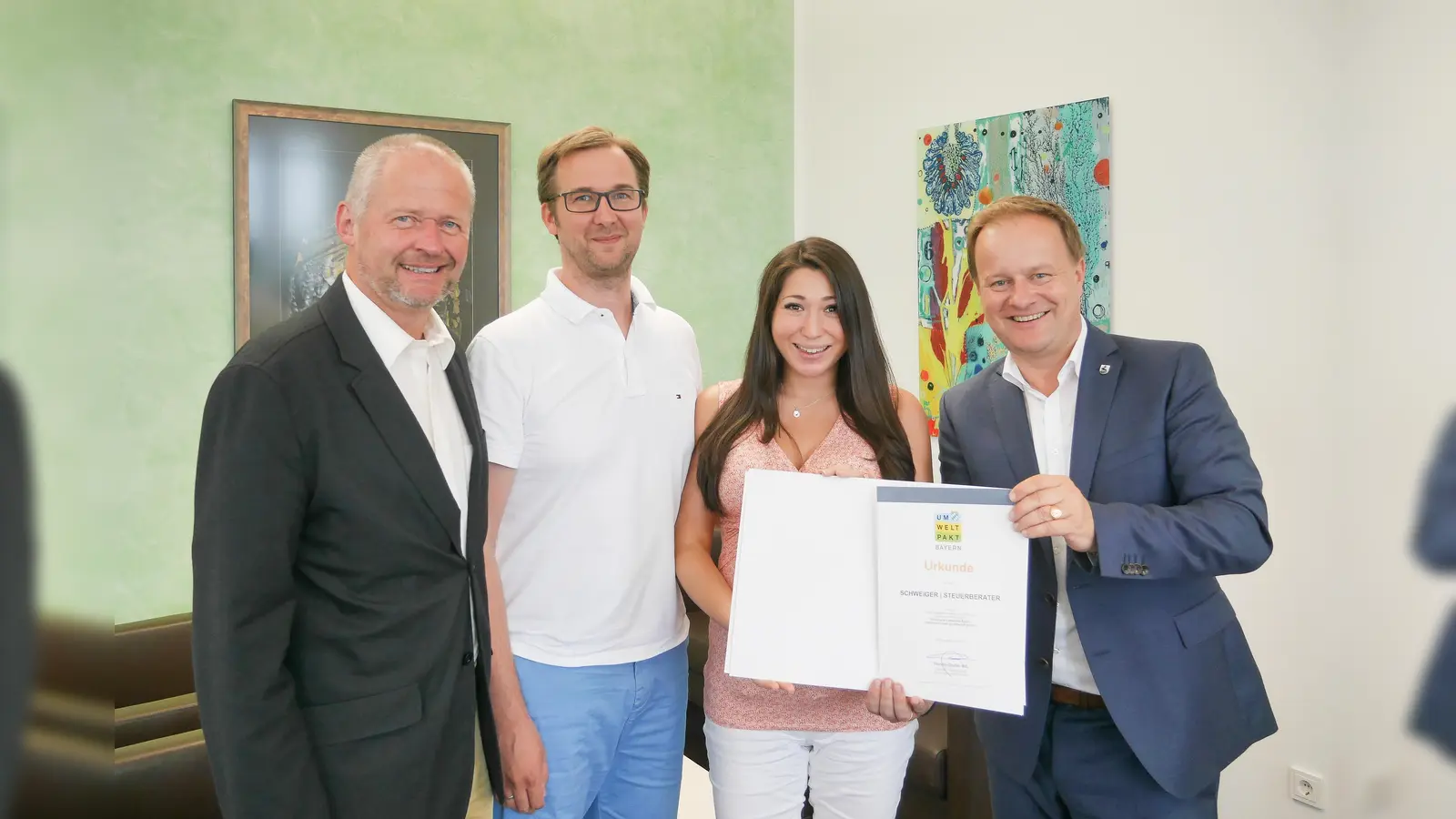 Augustinus Meusel, Wirtschaftsförderer des Landkreises, Richard Schweiger, Johanna Schweiger von der gleichnamigen Steuerberaterkanzlei in Poing und Landrat Robert Niedergesäß bei der Übergabe der Urkunde zum Umweltpakt Bayern im Landratsamt.  (Foto: VA)