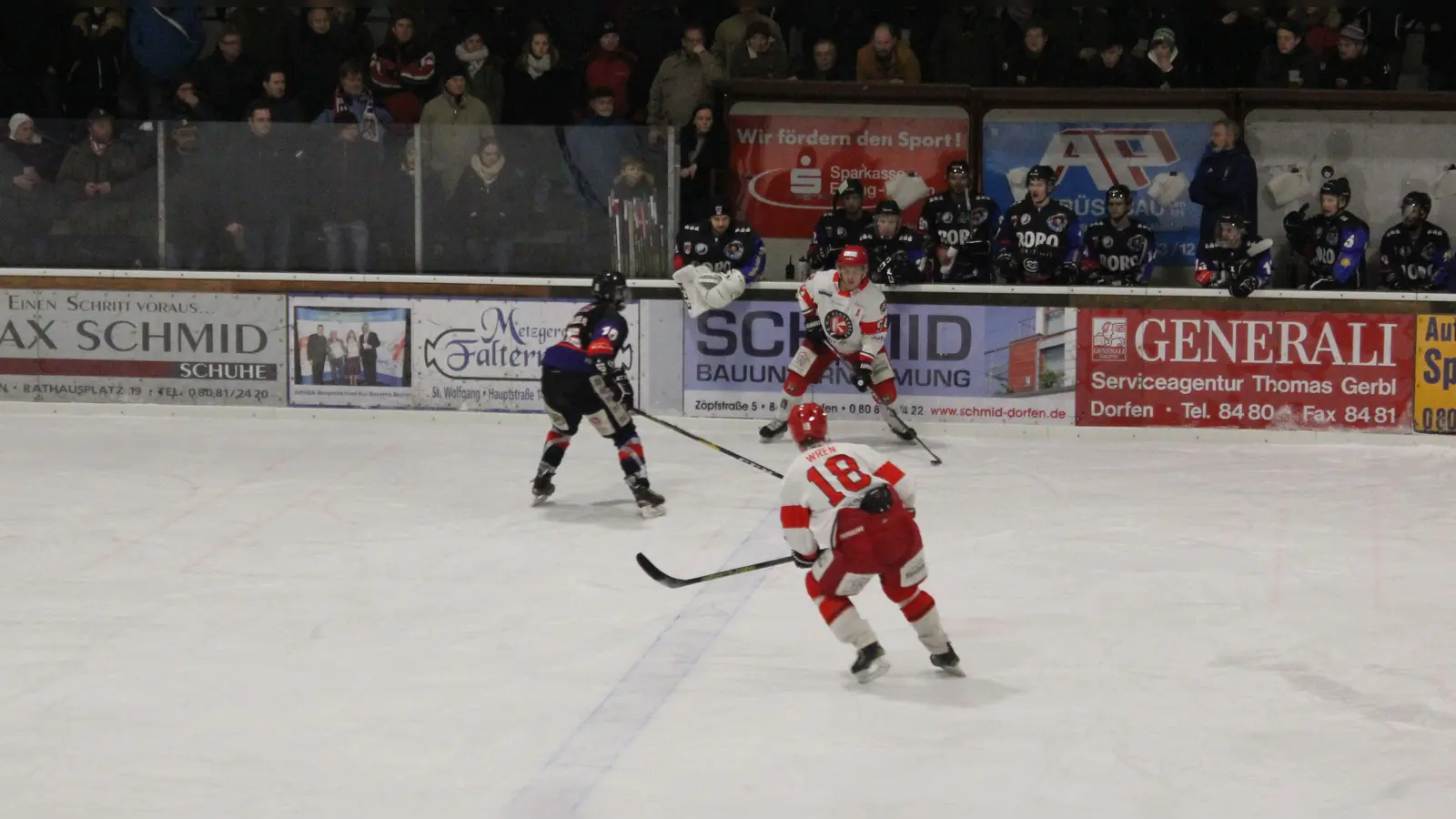 Szene mit den formstarken Bob Wren (#18) und Raphael Kaefer (#94, hinten, weißes Trikot) vom Auswärts-Derby des EHC Klostersee bei den Eispiraten Dorfen am zurückliegenden Freitag, das die Rot-Weißen dominierten und verdient mit 5:2 gewonnen haben. (Foto: smg)