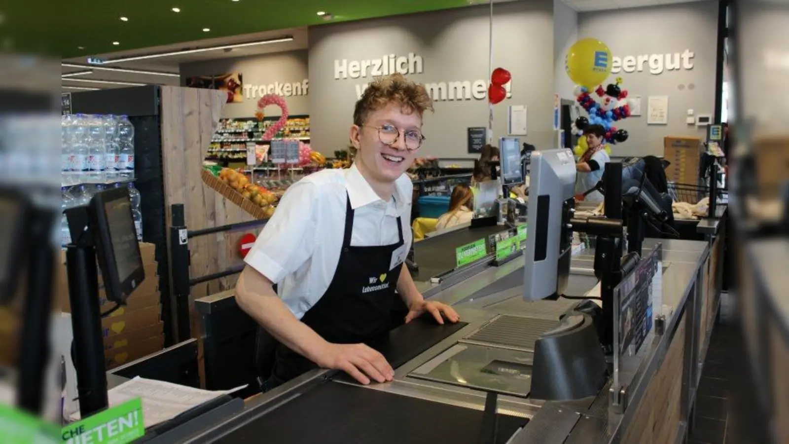 Urs Eckert, Auszubildender im 1. Lehrjahr: „Ich habe im September mit meiner Ausbildung bei EDEKA Südbayern begonnen und bin super zufrieden. Mir macht die Arbeit sehr viel Spaß, auch weil das Aufgabengebiet so abwechslungsreich ist. Und die Zusammenarbeit mit meinen Kollegen ist gut. Es geht sehr familiär zu. Große Freude macht mir auch der Umgang mit den Kunden. Ich freue mich immer, wenn richtig was los ist im Markt. Das ist eine gute Challenge. Hier im Azubi-Markt kann ich nun schon erste Erfahrungen sammeln, um zu erfahren, wie es ist, einen Markt eigenverantwortlich zu führen. Ich kann auch meine eigenen Ideen einbringen und schon jetzt sehr viel für meine berufliche Zukunft mitnehmen. Mein Ziel ist es, irgendwann selbst mal Marktleiter bei EDEKA Südbayern zu sein.“ (Foto: sb)