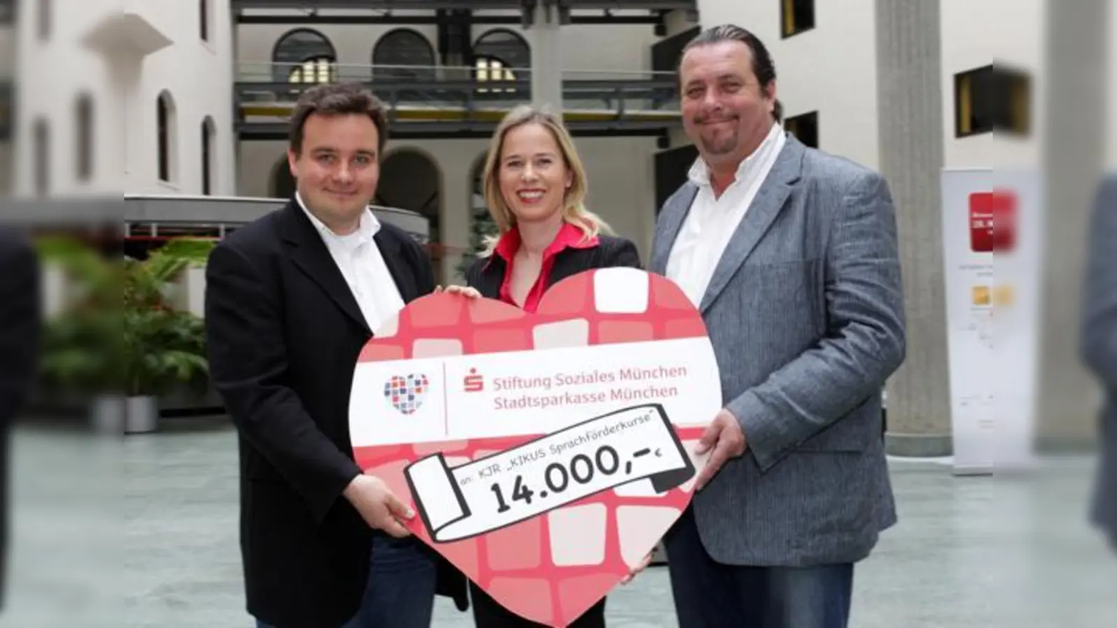 Andreas Giebel (re.), Schirmherr von Hilfe für Kids, nimmt das symbolische Spendenherz der Stiftung Soziales München dankend an. 	 (Foto: KJR)