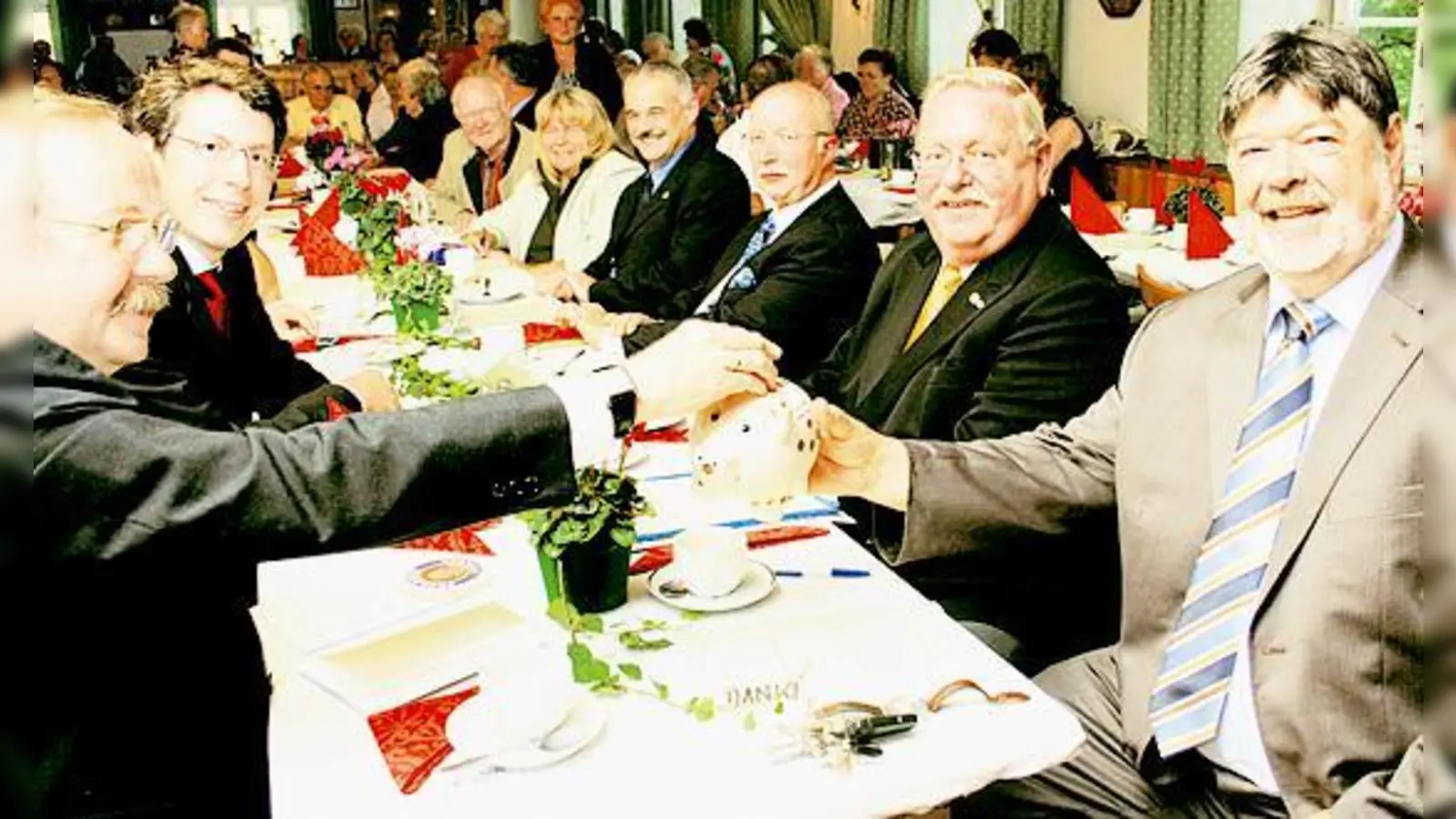 Die Gäste sollten eifrig das Spendenschwein für die Sanierung des Kriegerdenkmals füttern, Günter Jockisch ging mit gutem Beispiel voran.   (Foto: Hirt)