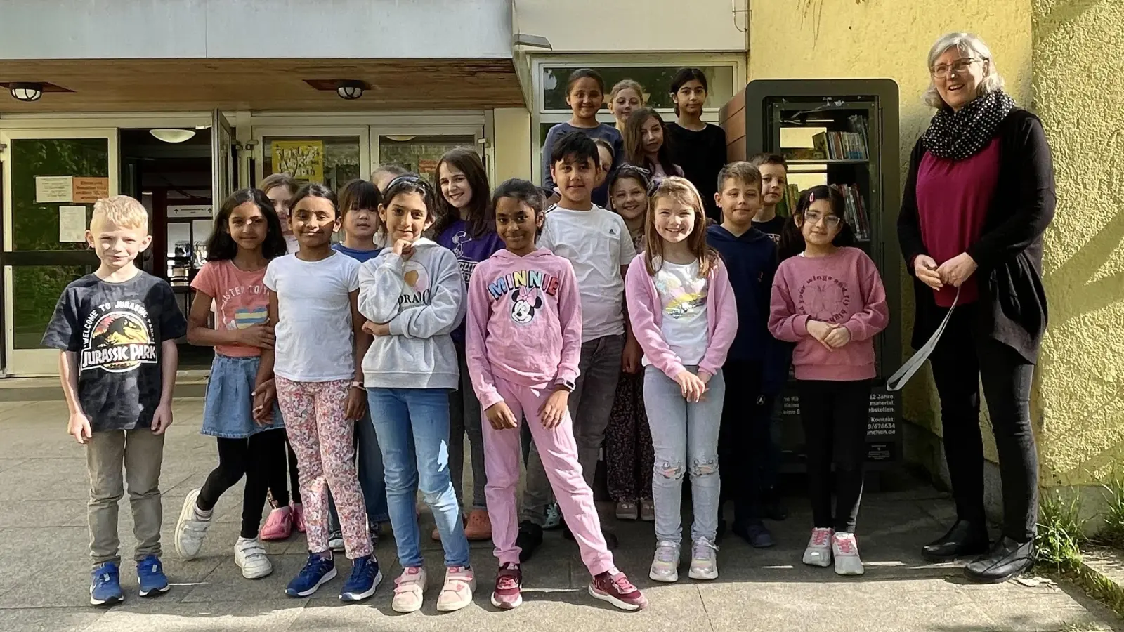 Rektorin Marion Lange freut sich gemeinsam mit einem Teil der Schüler der Grundschule an der Kafkastraße über den prall gefüllten Kinderbücherschrank. (Foto: hw)