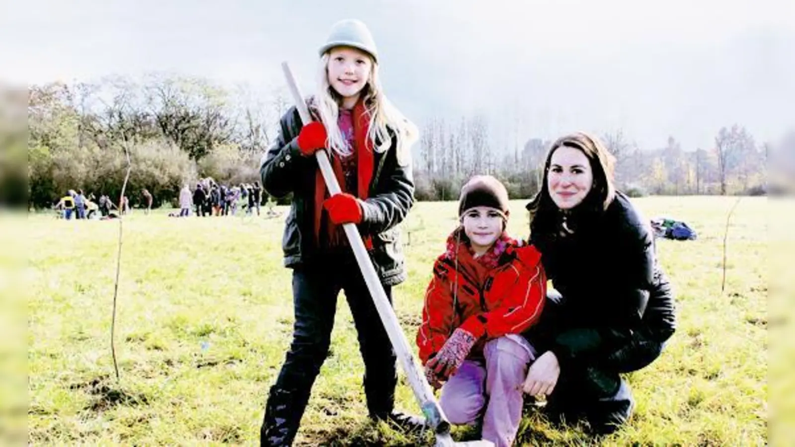 Marie Sophie (l.), Annette Kuzmany und Aulona pflanzen mit Klassenkameraden der Grundschule an der Burmesterstraße 300 Bäume für den Klimaschutz auf einem Lerchenauer Grundstück.	 (Foto: ko)