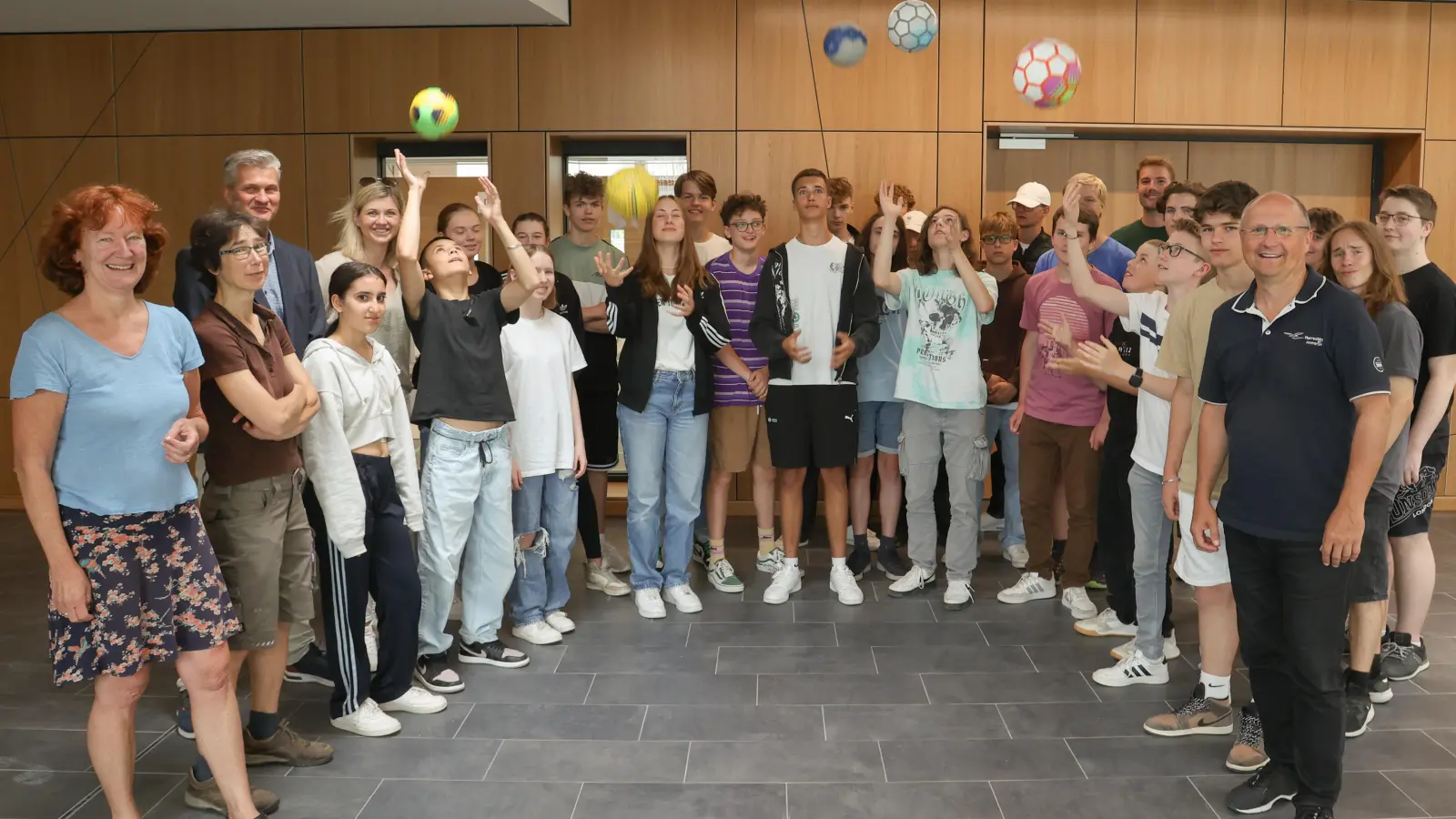 Übergabe der neuen Bälle an die Klasse 9a: Christiane Gruber, Franziska Kalz, Schulleiter Christian Schmitz und Melanie Wederhake (links) sowie Bürgermeister Christian Schiller (rechts) und Marius Lengenfelder (hinten rechts). (Foto: Gemeinde Herrsching)