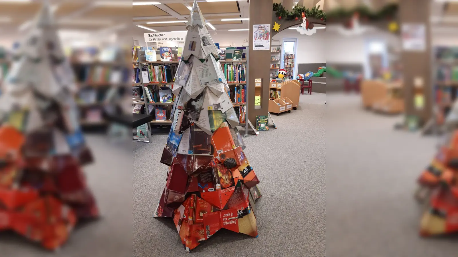 In der Gemeindebibliothek von Grünwald ist ein ganz besonderer Weihnachtsbaum zu bewundern. Er wurde aus alten Buchdeckeln gebastelt.  (Foto: Pohl)