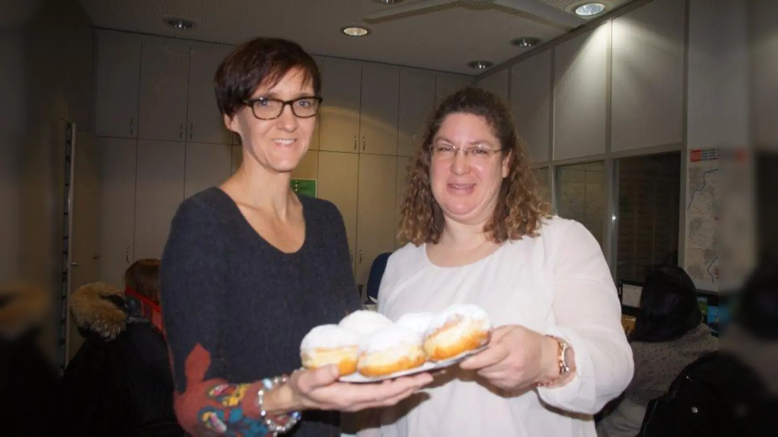 „Tolle Aktion! Ich bin total happy”, meinte Andrea Bieberle (r.) aus Karlsfeld, als sie ihren Krapfengewinn von Redakteurin Tanja Beetz überreicht bekam. Das duftende Gebäck sollte eine Überraschung für ihre Kollegen im KVR sein. (Foto: bb)