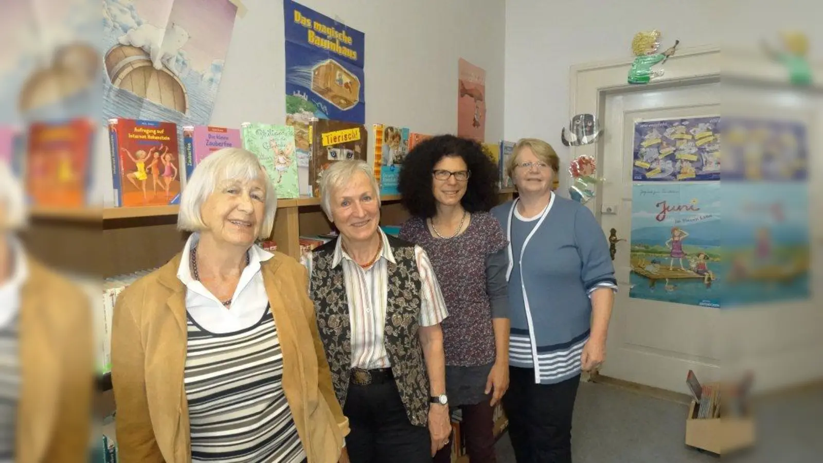 Seit zehn Jahren gibt es die Bibliothek in der Grundschule an der Implerstraße. Darüber freuen sich Biche Fischer (links), Schulleiterin Marion Dieck (zweite von rechts) und Margarete Moll (rechts). (Foto: tab)