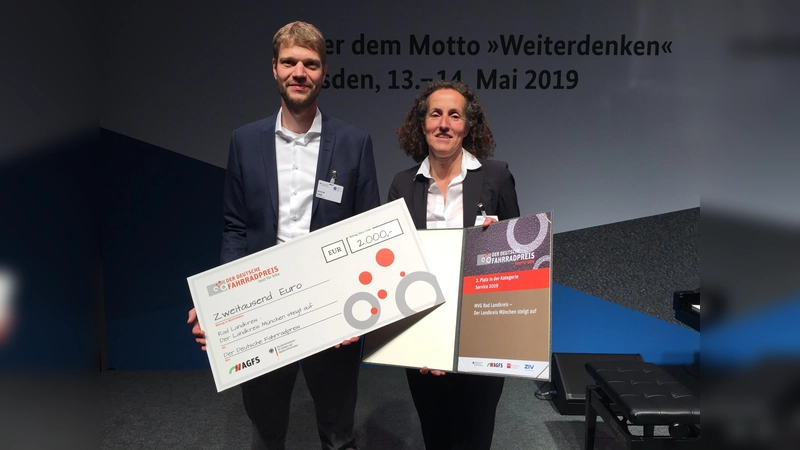 2.000 Euro erhält der Landkreis München für den zweiten Platz beim Deutschen Fahrradpreis. Dominik Lypp, Leiter des Projekts im Landratsamt, und Sonja Rube, Projektleiterin für die MVG, nahmen Scheck und Urkunde entgegen. (Foto: Landratsamt München)