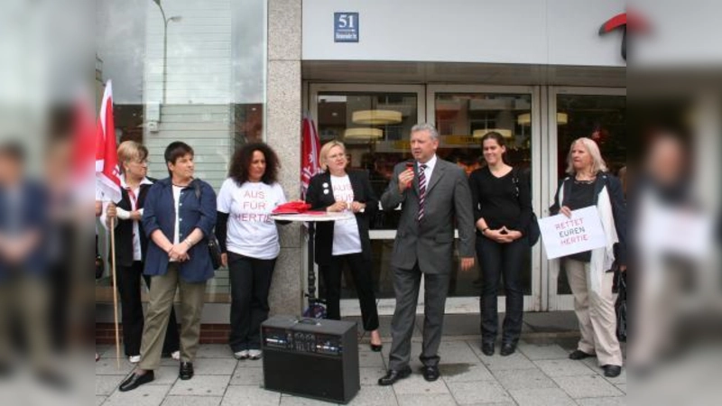 Günter Dechant, Geschäftsleiter der Laimer Hertie-Filiale bedankte sich bei Kunden, Mitarbeitern und Geschäftsleuten für  deren Unterstützung. Von links im „Aus für Hertie”-T-Shirt: Erika Scherzer, Christina Radinger, SPD-Stadträtin Verena Dietl und Margit Meier (SPD) vom Bezirksausschuss Laim. (Foto: tg)