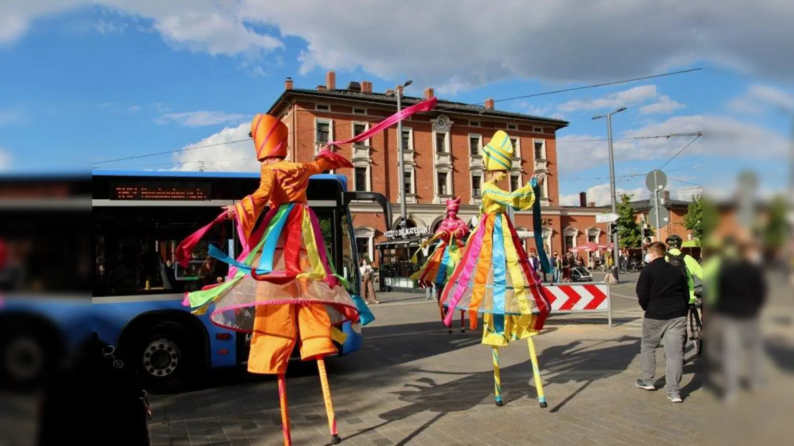 Buntes Spektakel vorm Pasinger Bahnhof: das ZEBRA Stelzentheater führte sein Programm „Dances around the world“ auf. Ermöglicht hatte den Auftritt die Initiative „Kulturlieferdienst”. (Foto: us)