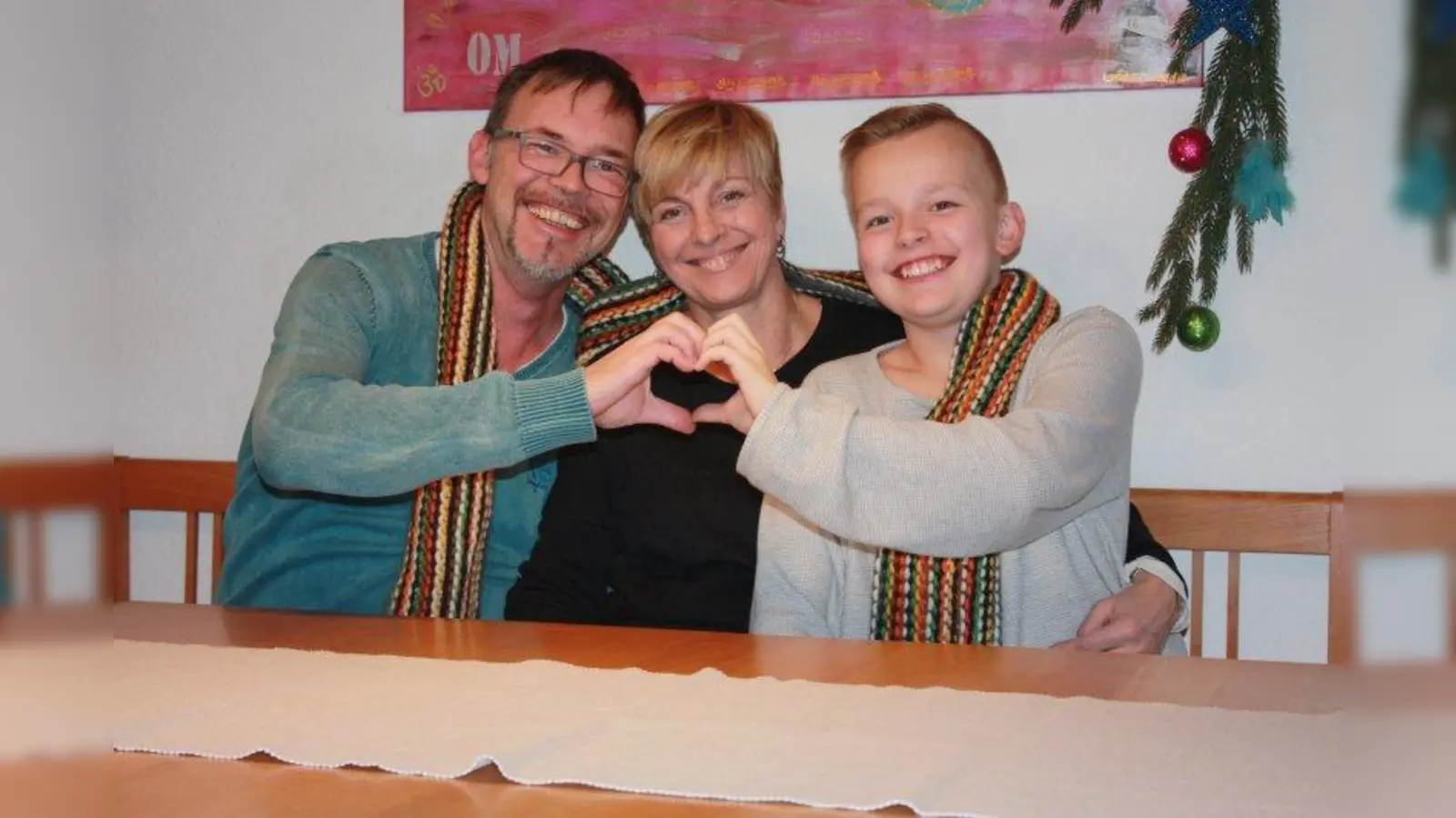 Gerhard Schumann, Ehefrau Monika und der elfjährige Sohn Moritz haben sich einen „Schal des Lebens” umgehängt. Damit werden syrische Flüchtlingskinder unterstützt. (Foto: Schumann)
