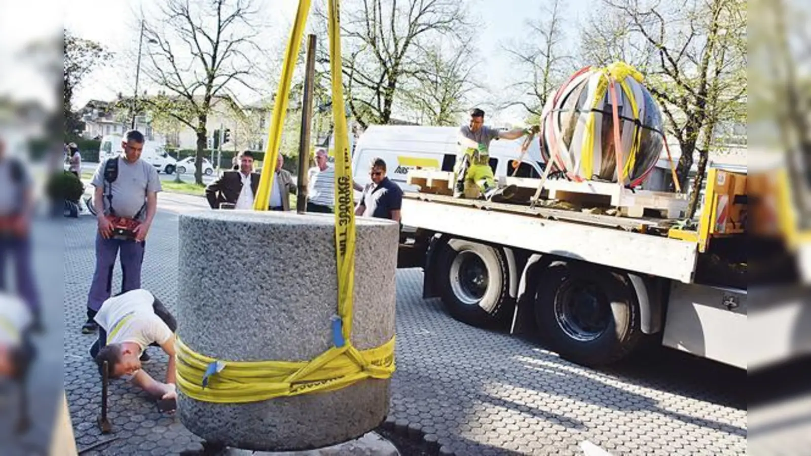 Die Große Bilderschriftkugel ist verladen (hinten). Zurück vor dem Unterföhringer Rathaus bleibt bis Ende Oktober nur der Sockel.	 (Foto: Gemeinde Unterföhring/foe)