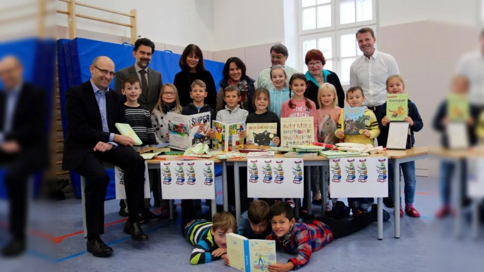 „Bei euch haben unserer Bücher ein Zuhause gefunden. Viel Spaß damit!“ Klaus Beckschulte (l.) vom Börsenverein des Deutschen Buchhandels übergab über 100 Bücher an die Grundschule am Schererplatz. Franz Mitterer vom Staatlichen Schulamt, Schulleiterin Anita Bock, stellvertretender Schulleiter Markus Schättler (v.l.) und die ehrenamtlichen Helfer aus Schulbücherei und Elternbeirat Sabine Haberfelner, Robert Bauer und Erna Bauer-Forster übernahmen die Bücher mit begeisterten Zweitklässlern. (Foto: us)