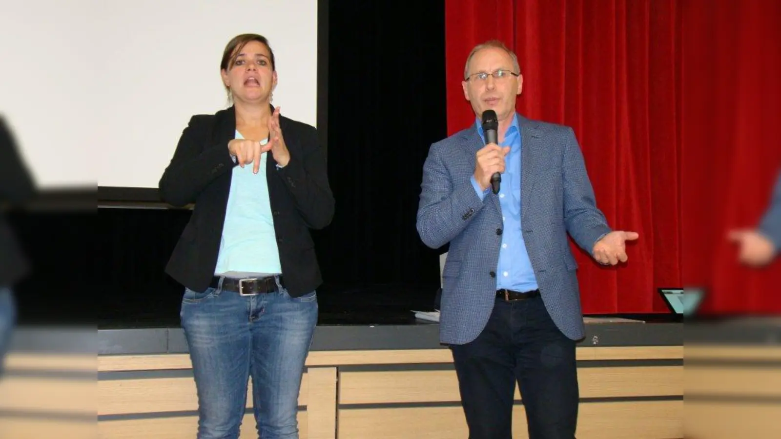 „Sprechende Hände”, li. die Gebärdensprachdolmetscherin Michaela Weisgerber, re. Vertreter des Landratsamts Friedrich Büttner. (Foto: pst)