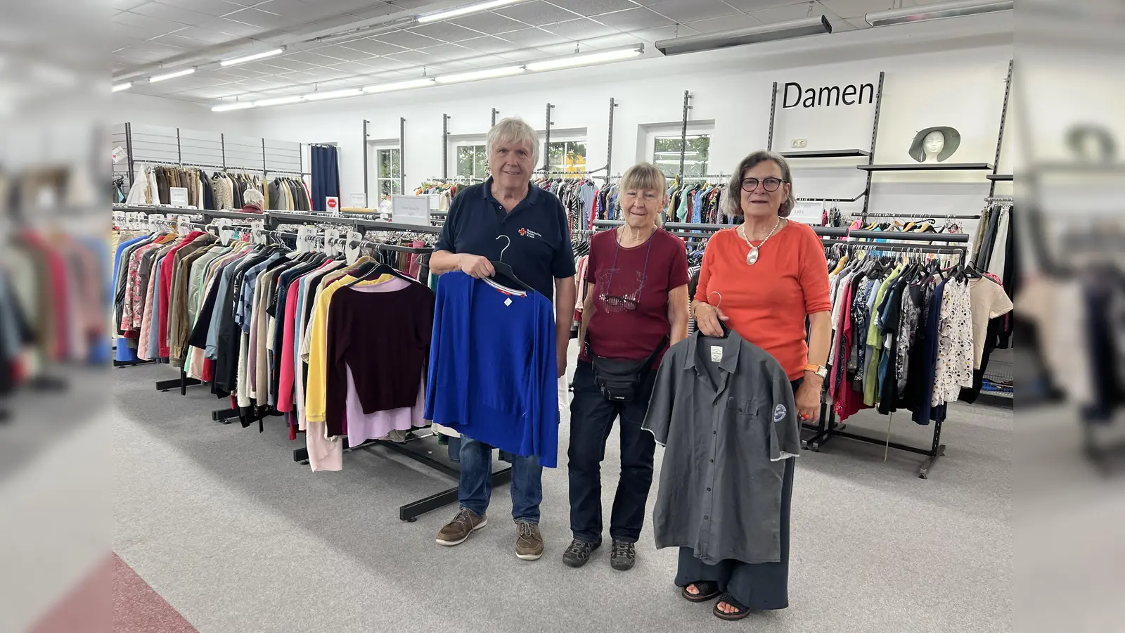 Günther Wolf, die Leiterin des Rotkreuzshops in Karlsfeld Renate Weger und Helferin Angela Eben-Reischl im RotKreuzShop in Dachau-Ost. (Foto: BRK - Kreisverband Dachau)